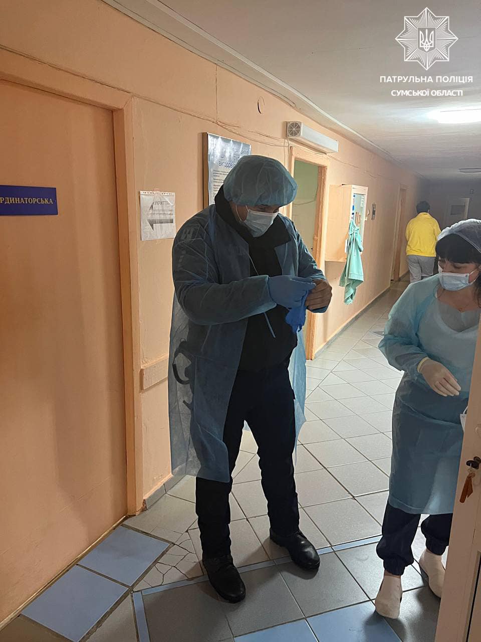 Фото полицейского, надевающего халат и маску. Источник - Фейсбук